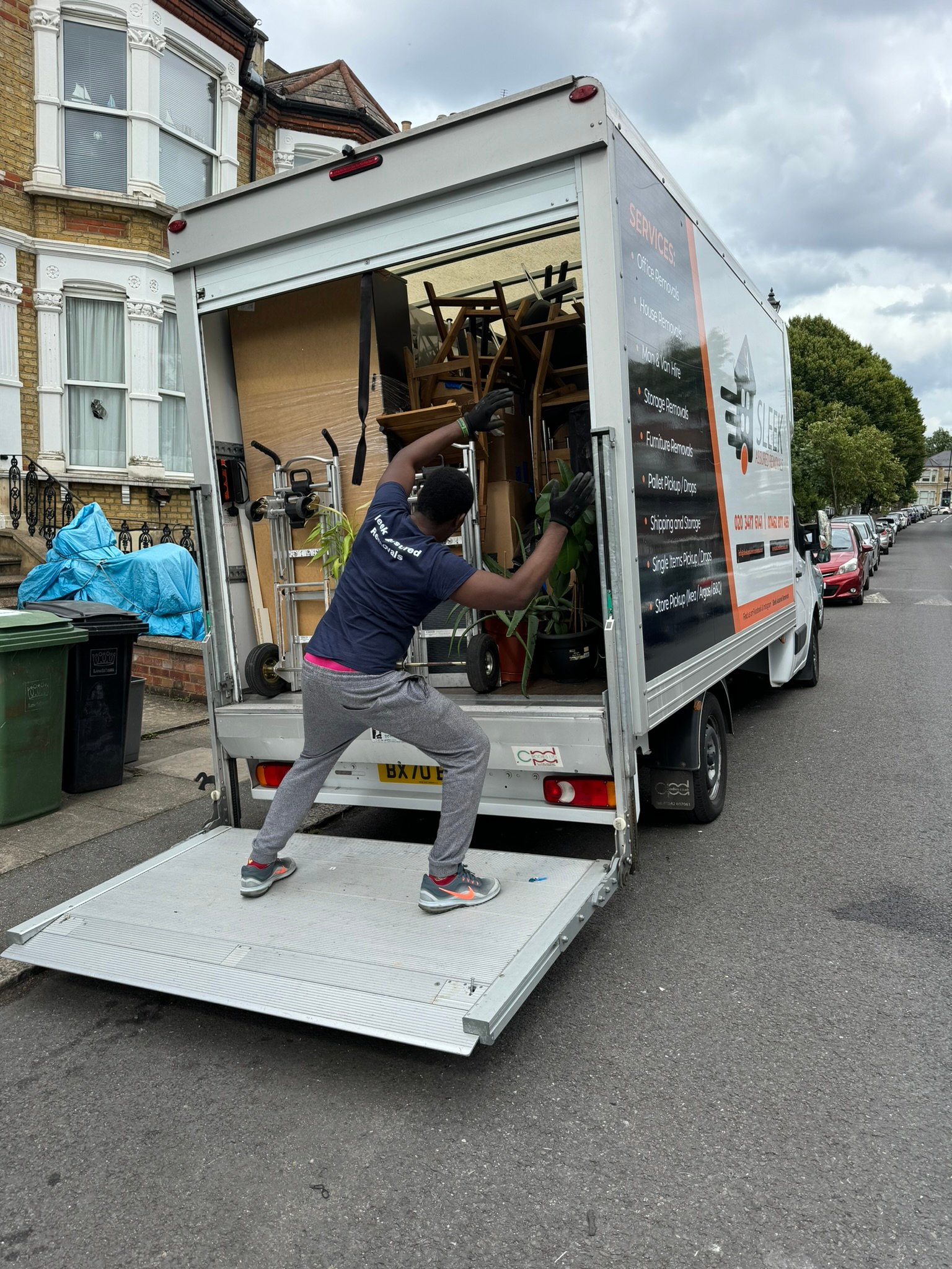 A worker is loading a van to move household goods.