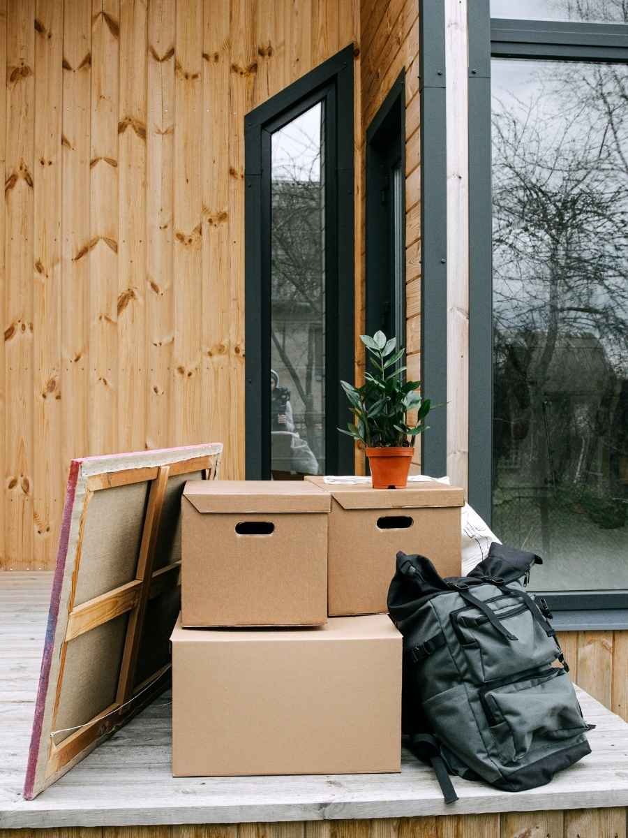 Furniture, boxes, and flower pots stacked together outside a house